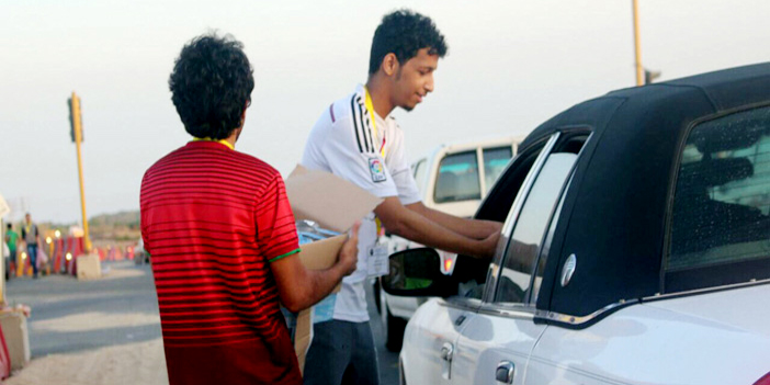  متطوعان أثناء توزيع الوجبة لأحد المسافرين