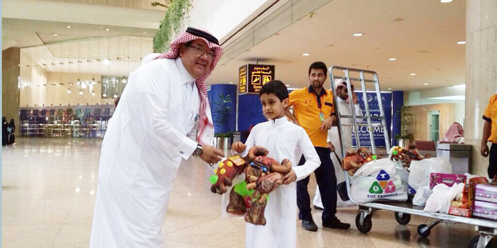  توزيع الهدايا في المطار على المسافرين