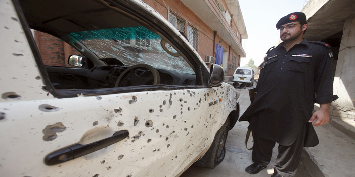  رجل أمن باكستاني يقف على سيارة متضررة من الانفجار الانتحاري