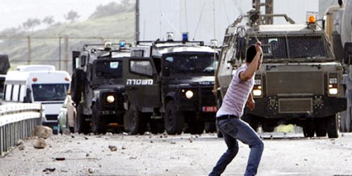  شاب فلسطيني يلقي الحجر على قوات الاحتلال