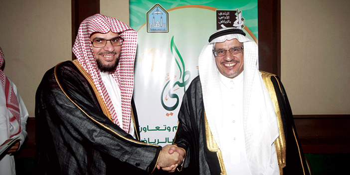  د. أحمد العضيب يصافح د. الحيدري بعد توقيع الاتفاقية