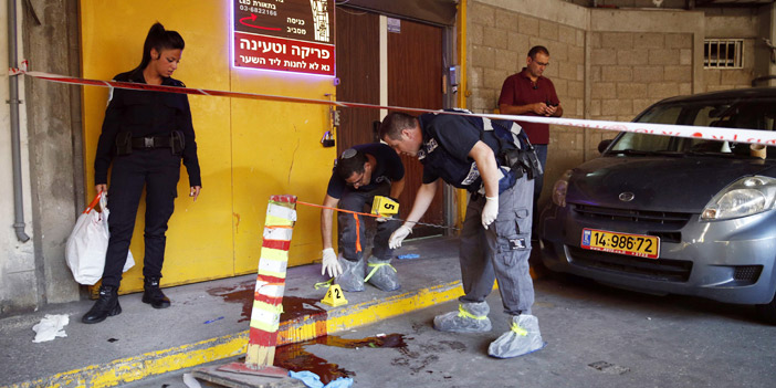  محققون إسرائيليون يعاينون موقع هجوم على إسرائيليين في تل أبيب