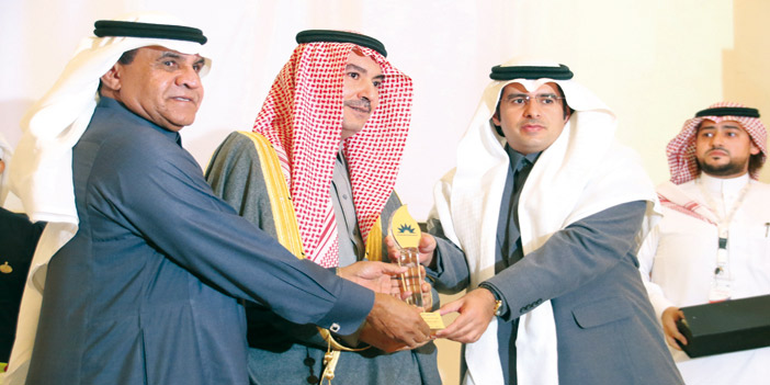  الزميل محمد الفيصل أثناء تسلّمه الجائزة بالنيابة عن رئيس التحرير من الأمير تركي بن محمد وحمود الذييب