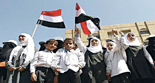  طلاب وطالبات يمنيون يحملون العلم اليمني ويرددون النشيد الوطني