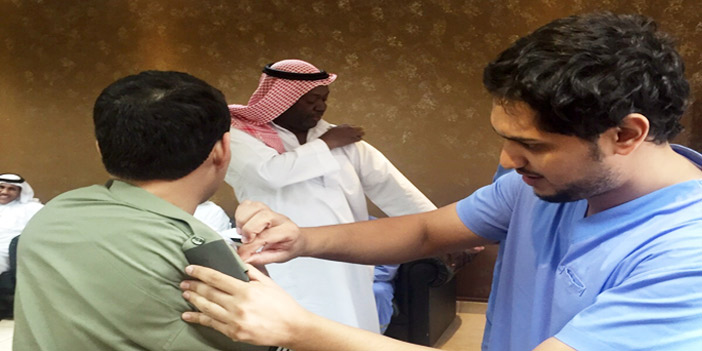  أحد منسوبي الجوازات خلال حملة التطعيم