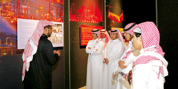 عدد من الشباب يقفون للاستماع إلى معلومات خلال زيارتهم للمعرض
