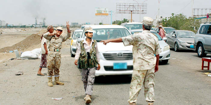  جندي من قوات الجيش اليمني يرفع علامة النصر في إحدى نقاط التفتيش