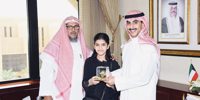  الشيخ ثامر الصباح يقدِّم درعاً تذكارياً للطفلة شريفة الحقباني وبجانبها والدها