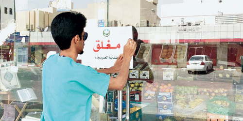  مراقب من بلدية البطحاء يضع لافتة (مغلق محل)