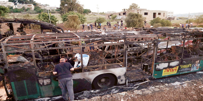  الحافلة وقد احترقت بالكامل وخبراء المتفجرات الإسرائيليون يبحثون عن أدلة