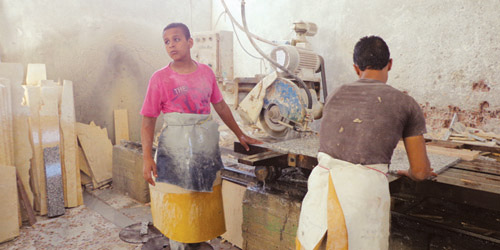  عمال في أحد مصانع تقطيع القرميد والحجر