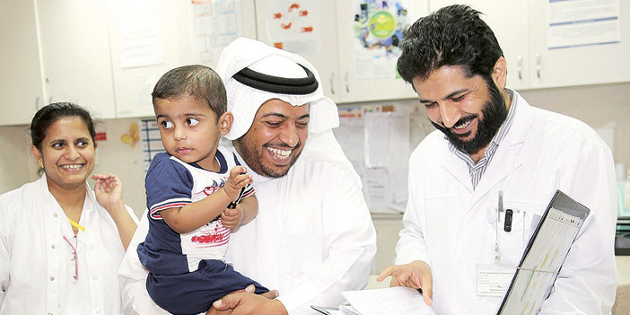  د. عبدالله الوادعي أحد أفراد الطاقم الطبي مع الطفل ووالده