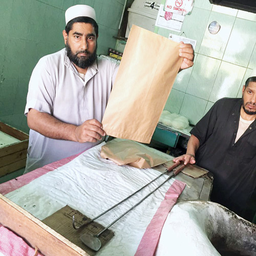  خباز يحمل كيساً ورقياً بدلاً من البلاستيكي