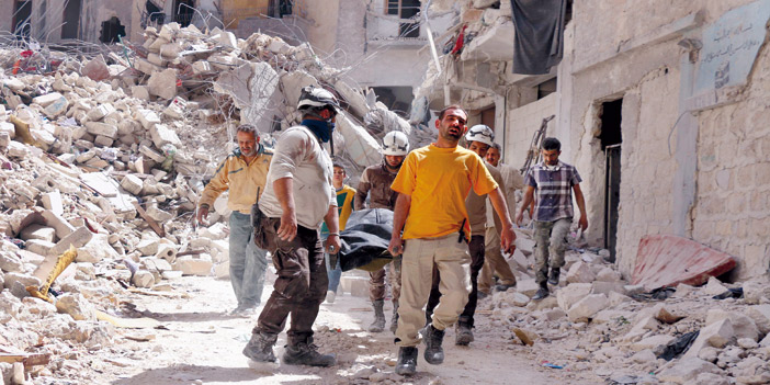  مسعفون يحملون مصابين جراء قصف النظام على حلب