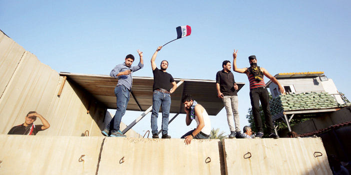   المتظاهرون يلوحون بالعلم العراقي لحظة اقتحامهم المنطقة الخضراء.
