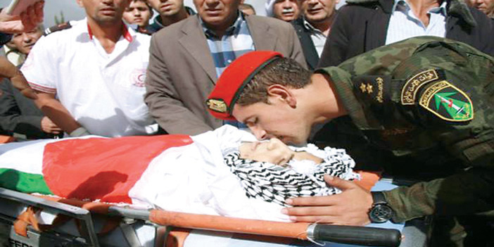   رجل أمن فلسطيني يقبل رأس شهيد