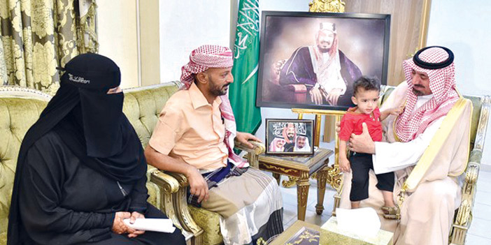   الأمير جلوي محتضنًا الطفل اليمني مع أسرته