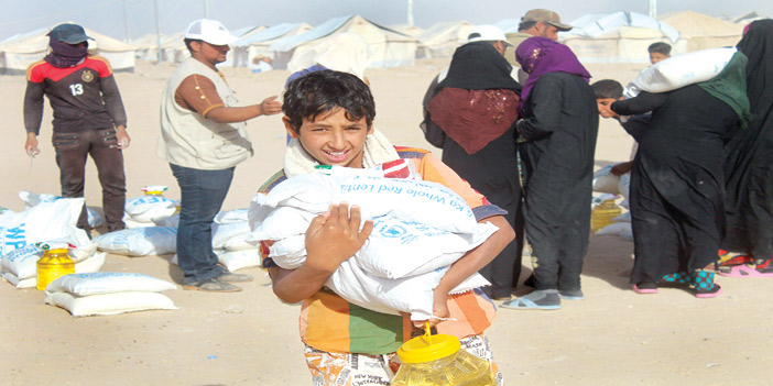  طفل عراقي نازح من المعارك في الفلوجة يحمل كيس إغاثة للأمم المتحدة