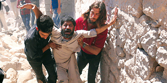   إنقاذ سوري من تحت أنقاض أحد المباني المدمرة جراء غارات النظام