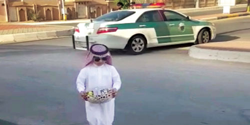  الطفل يقوم بتوزيع الحلويات على رجال الأمن