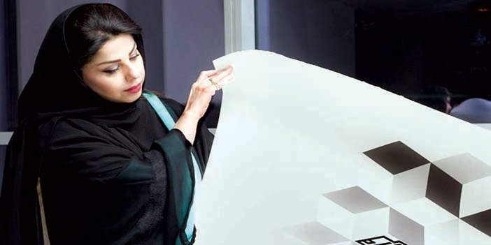  الفنانة لولوة الحمود مع إحدى لوحاتها