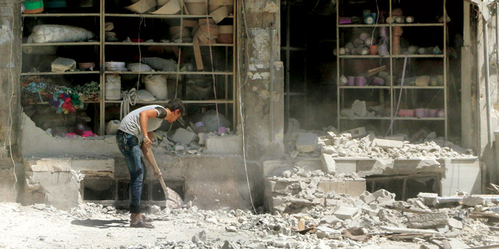 شاب سوري يبعد الركام الذي خلفه قصف الأسد أمام محله في حلب