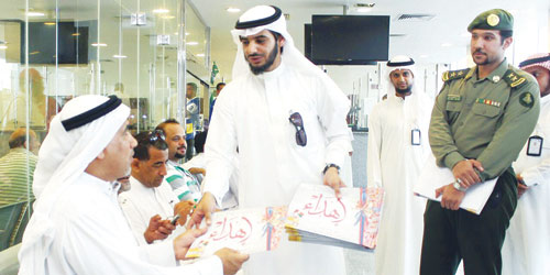   أثناء توزيع الكتيبات على الحجاج القادمين للمملكة من البحرين