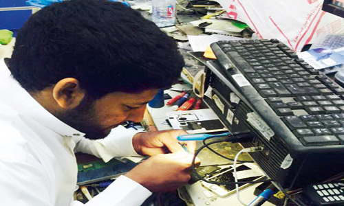  شاب سعودي يمارس صيانة أجهزة الجوالات بأحد مجمعات الاتصالات
