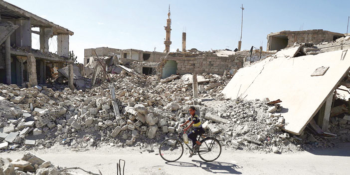   طفل سوري يقود دراجته بين ركام المنازل المدمرة بدوما