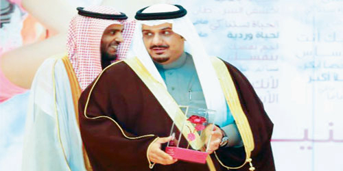   الأمير نواف لحظة تكريمه من جمعية «زهرة»