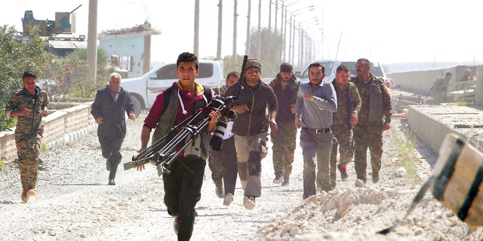  أفراد من قوات سوريا الديموقراطية ينزحون إلى إحدى مناطق القتال الدائر بينهم وبين داعش