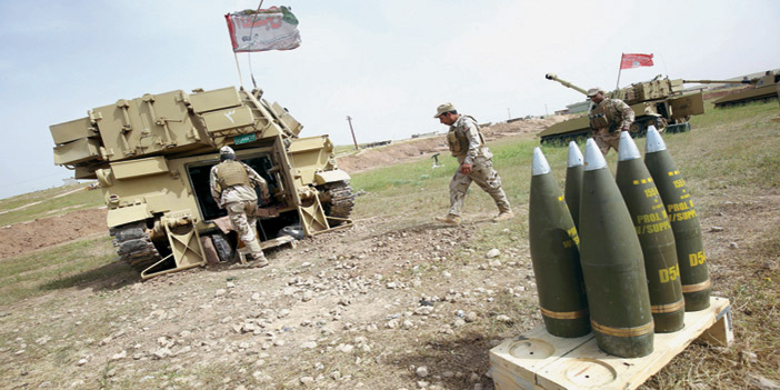  جنود عراقيون يجهزون القذائف في حربهم ضد داعش