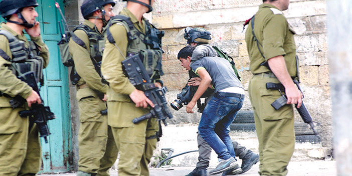  جنود الاحتلال الإسرائيلي أثناء اعتقالهم شابا فلسطينياً