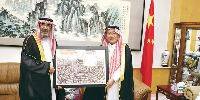  السفير الصيني بالزي السعودي يتلقى الهدية من د.الوهيبي