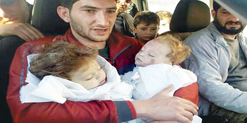  سوري يحمل طفليه التوأم اللذين فقدهما في الهجوم الكيماوي