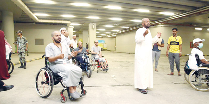  أفراد من جمعية حركية أثناء الدعاء لخادم الحرمين الشريفين وولي عهده