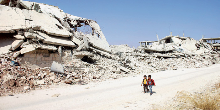  أطفال سوريون متوجهون إلى المدارس في مدينة درعا المدمرة