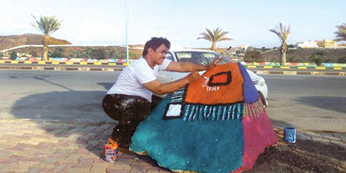  الفنان البارقي خلال تنفيذه لأحد أعماله الميدانية