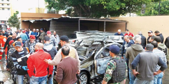  الأمن اللبناني والمسعفون يحيطون بسيارة القيادي المحترقة من جراء الانفجار