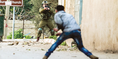  جندي إسرائيلي يترصد شبان فلسطينيين في قرية برقين