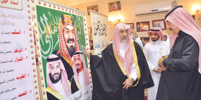  د.أبا الخيل يقف إلى جانب صورة المؤسس والملك سلمان والأمير محمد بن سلمان خلال تفقده الإسطبل