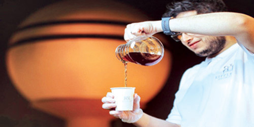  الشاب عبدالله أثناء إعداد القهوة لزبائنه