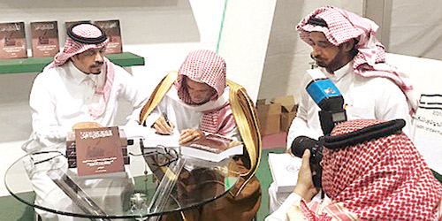  د.الفيصل أثناء توقيع كتابه للأستاذ بندر بن عثمان الصالح