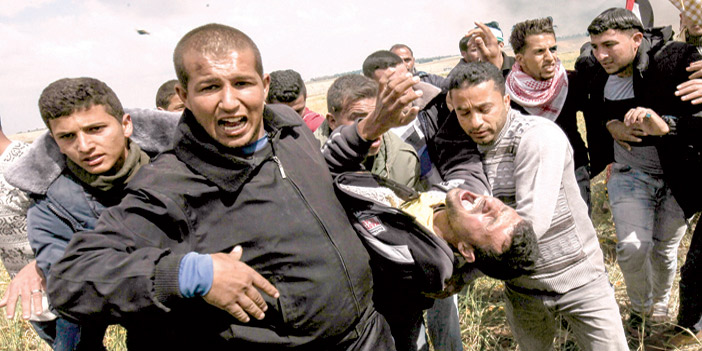  فلسطينيون يحملون مصاباً في مظاهرات ضد الاحتلال الإسرائيلي
