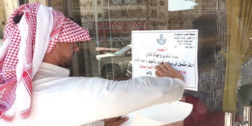  لجنة تطوير المباني تضع إشعاراً على أحد المحلات لتحسينها