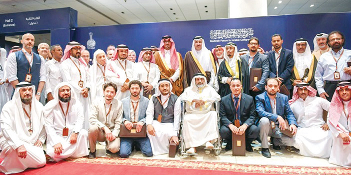  الأمير فيصل ونائبه في صورة تذكارية مع الخطاطين المشاركين