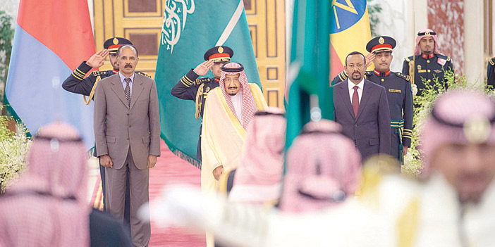  الملك يتوسط ضيفي المملكة خلال عزف السلام الملكي