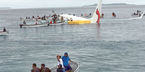 عمال إنقاذ يحيطون بطائرة «اير نيوجيني» 