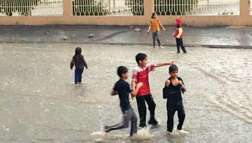  مجموعة أطفال يلهون تحت زخات الأمطار في مكة المكرمة