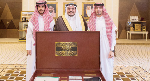  سموه يتسلم نسخة من التقرير وبجانبه الدهش